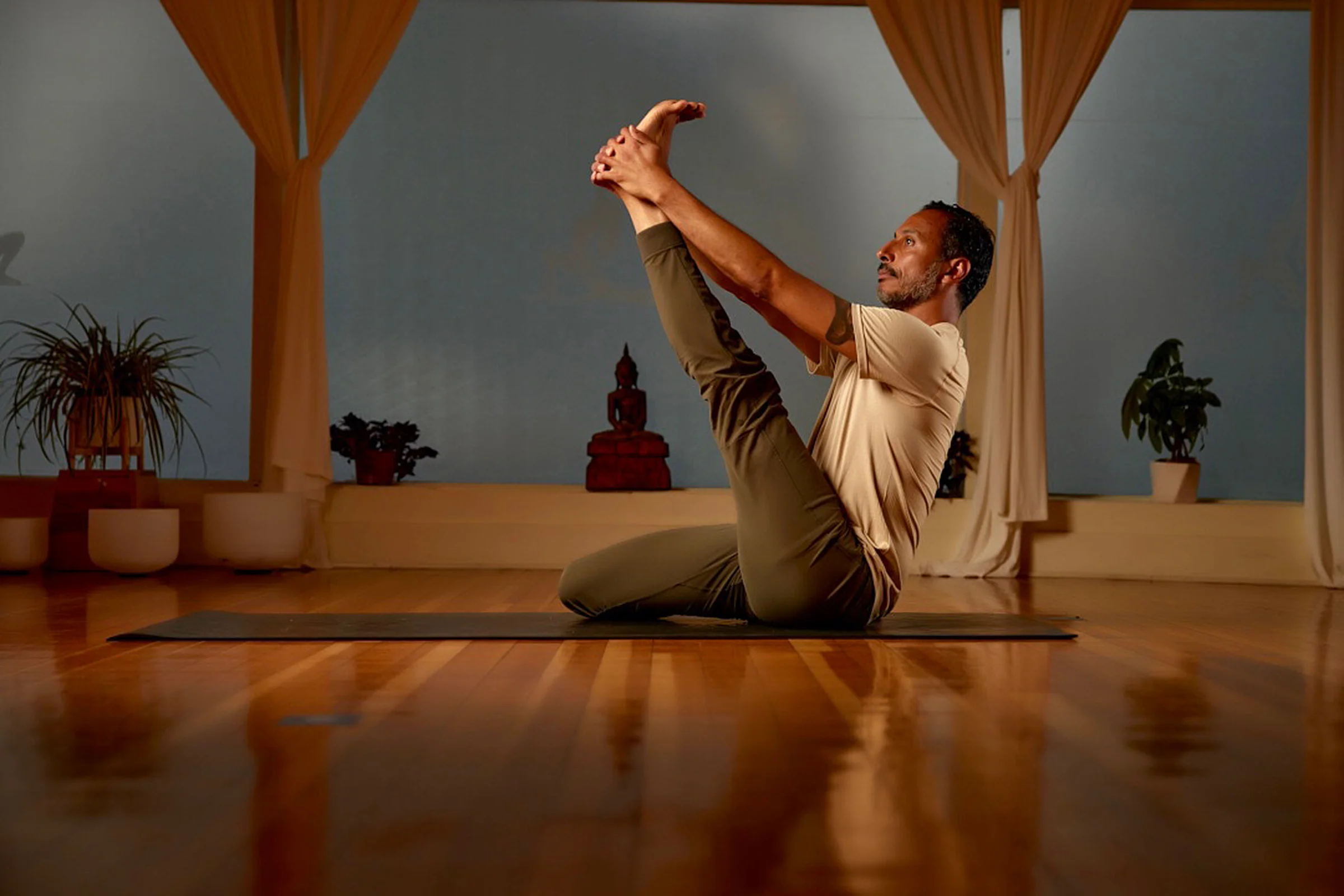 Jano Galindo practicing boat pose in the studio.